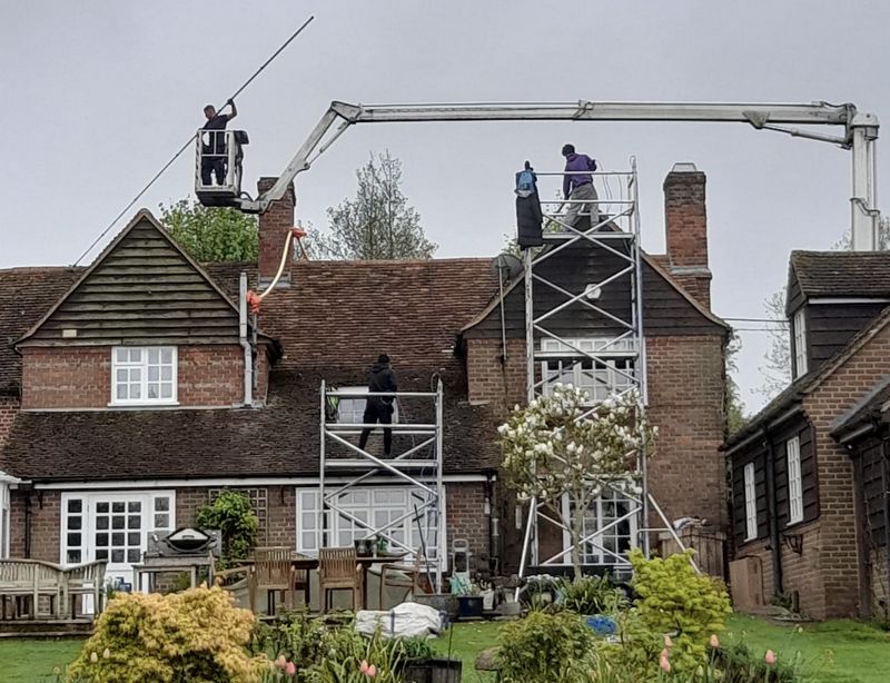 The Moss Cleaners using cherry picker and scaffolding to clean roof safely and professionally in East Grinstead, West Sussex